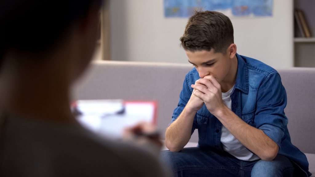 Sorrowful teenager on psychologist appointment, feeling guilty about behavior